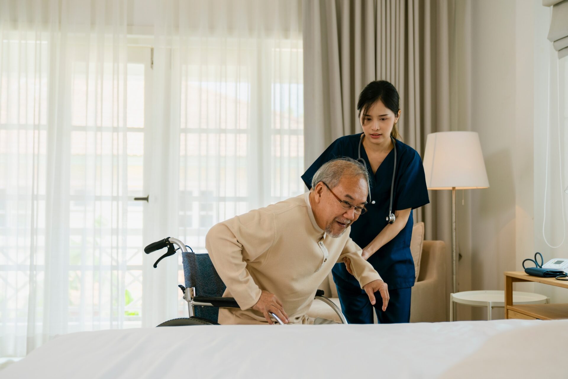 Happy older patient on wheelchair with female nurse